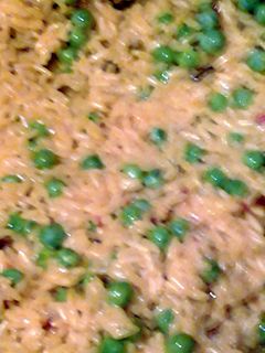 A picture of saffron yellow rice and sweet peas.