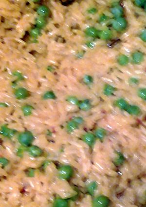 A picture of saffron yellow rice and sweet peas.