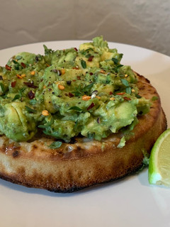 A picture of Smashed avocado(gaucamole style) on toasted crumpet.