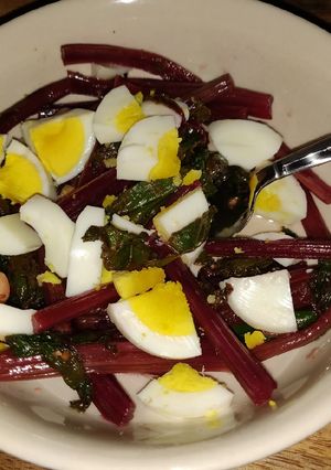 A picture of Sauteed beet greens with hard boiled egg.