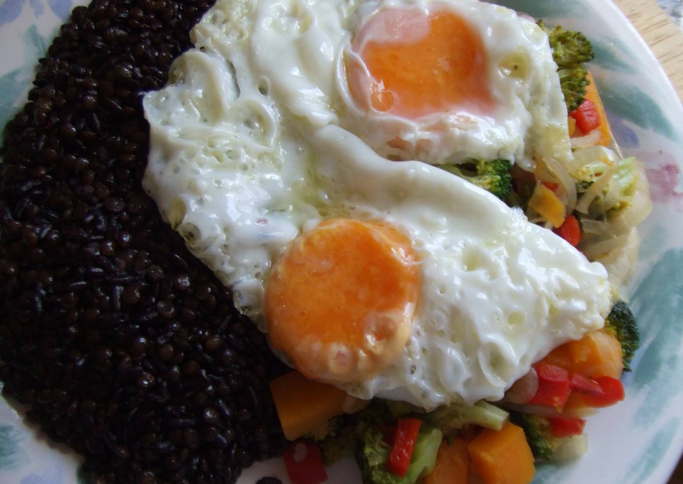 Plato vegetariano de arroz negro y lentejas con hortalizas