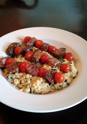 A picture of Grilled lamb and tomato kabobs with mushroom, lemon, amd parmesan couscous.