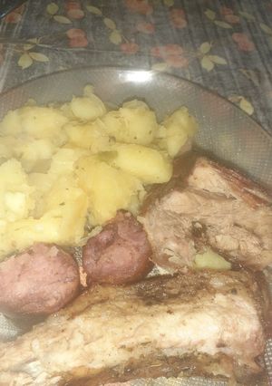 Una foto de Pechito de cerdo, chorizos con papas chilenas