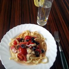 A picture of Tomato pasta with olives and mozzarela.