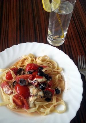 A picture of Tomato pasta with olives and mozzarela.