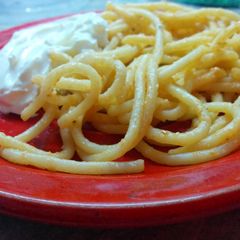 A picture of Spaghetti under white sauce.