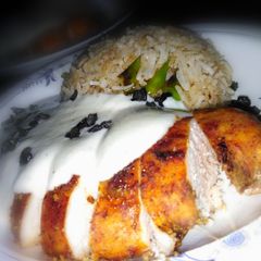 A picture of Chicken steak with chilli garlic rice and white sauce.