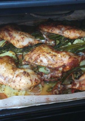 Una foto de Muslos de pollo al horno adobado, con camita de verduras