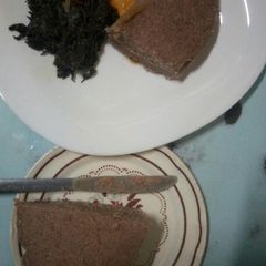 A picture of Chicken stew, brown ugali and mchicha.