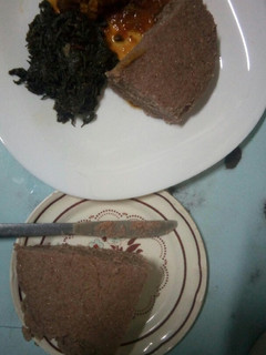 A picture of Chicken stew, brown ugali and mchicha.