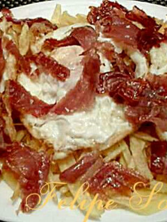 Una foto de Huevos rotos con patatas paja, y jamón serrano
