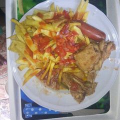 A picture of French fries with stewd chicken.