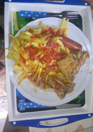 A picture of French fries with stewd chicken.