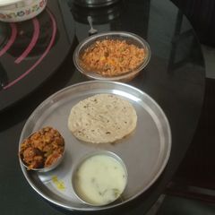 A picture of Pulav kadhi capsicum tomato peanut sabji and roti.