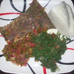 A picture of Wet fried fish, kales with Ugali.