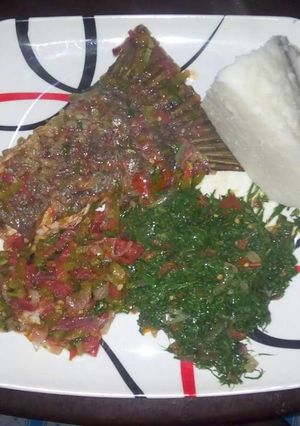 A picture of Wet fried fish, kales with Ugali.