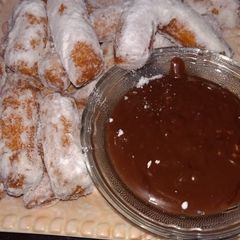 A picture of Churros with chocolate sauce.