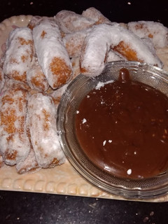 A picture of Churros with chocolate sauce.