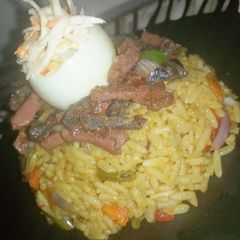 A picture of Fried rice,peppered liver and sausage with coleslaw.