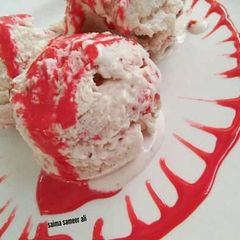 A picture of Homemade strawberry ice cream with homemade strawberry sauce.