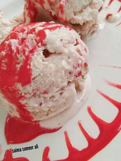 A picture of Homemade strawberry ice cream with homemade strawberry sauce.
