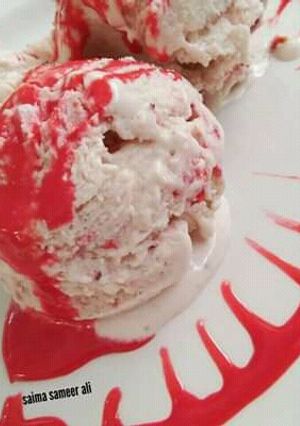 A picture of Homemade strawberry ice cream with homemade strawberry sauce.