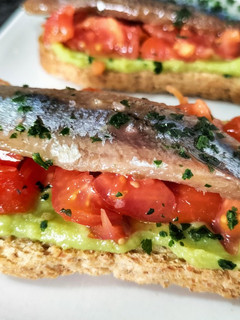 Una foto de Tostada de sardina ahumada con guacamole y tomate