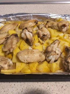 Una foto de Alitas con patatas y cebolla al horno😊