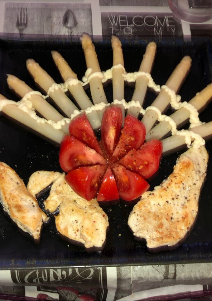 Una foto de Pechuga de pollo a la plancha con flor de tomate y espárragos blancos