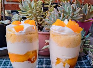 Una foto de Postre de durazno y chantilly en vaso
