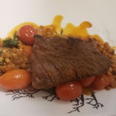 A picture of Seared skirt steak over spiced lentils.