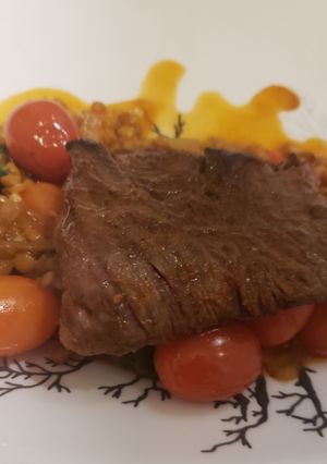 A picture of Seared skirt steak over spiced lentils.