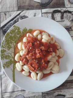 Una foto de Ñoquis con carne de hamburguesa bacon y tomate