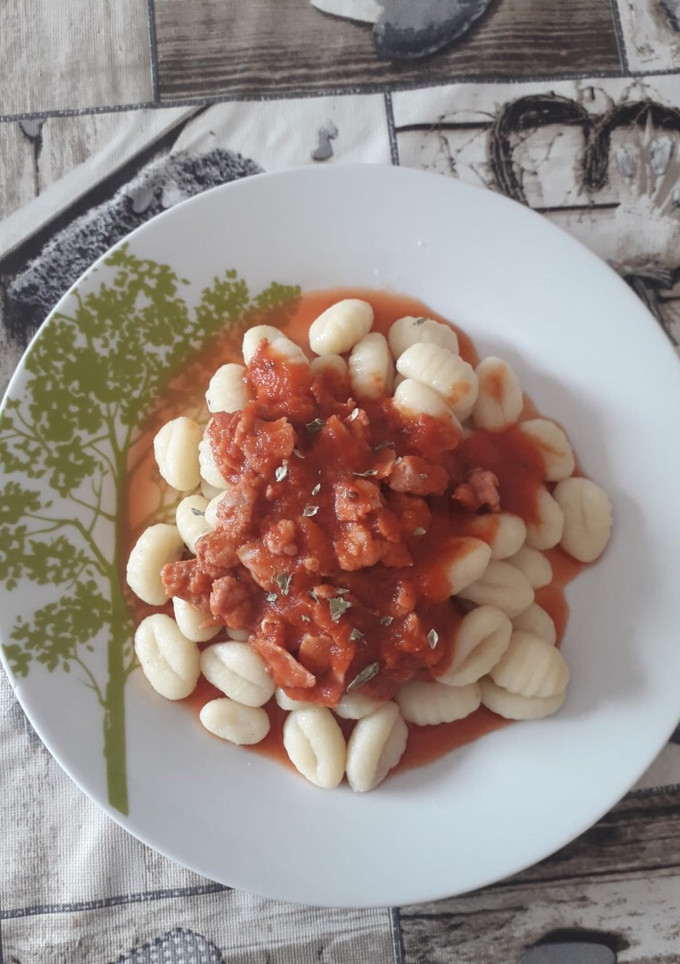 Una foto de Ñoquis con carne de hamburguesa bacon y tomate