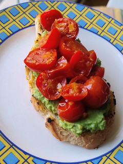Una foto de Tostón de aguacate y tomate confitado