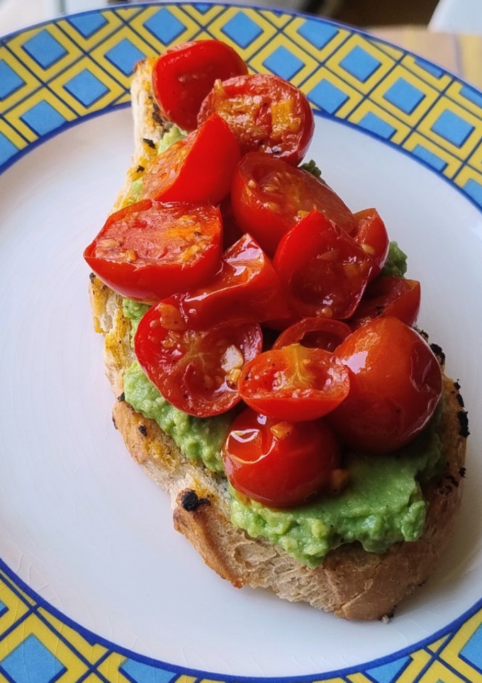 Una foto de Tostón de aguacate y tomate confitado