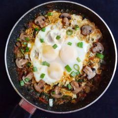 A picture of Spinach mushroom with egg in Shakshuka style.