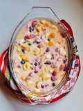 Postre multifruta (banana, naranja, durazno, frutillas, uvas pasa) con leche condensada casera