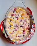 Postre multifruta (banana, naranja, durazno, frutillas, uvas pasa) con leche condensada casera