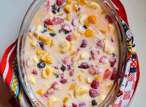 Una foto de Postre multifruta (banana, naranja, durazno, frutillas, uvas pasa) con leche condensada casera