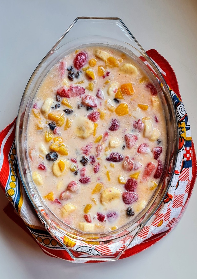 Una foto de Postre multifruta (banana, naranja, durazno, frutillas, uvas pasa) con leche condensada casera
