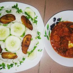 A picture of Boiled rice with fried plantain and fish stew.