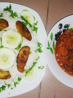 A picture of Boiled rice with fried plantain and fish stew.