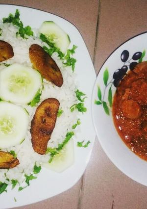 A picture of Boiled rice with fried plantain and fish stew.