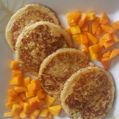 A picture of Pancakes With Mango Chunks & honey.