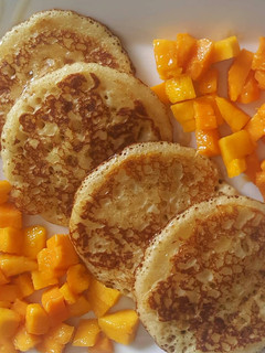 A picture of Pancakes With Mango Chunks & honey.