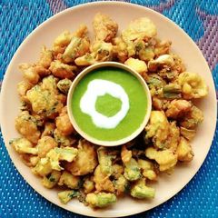 A picture of Spring onion and cauliflower fritters with mint leaves chutney.