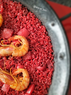 Una foto de Paella roja de sepia y gamba alistada con fumet de alga fucus y rape
