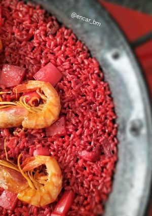 Una foto de Paella roja de sepia y gamba alistada con fumet de alga fucus y rape