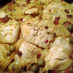 A picture of yellow rice and baked chicken.